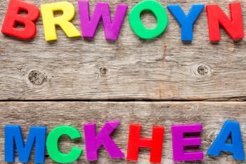 Old wooden background with multicolored toy letters