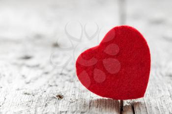 Red wool  heart shape on grungy wooden floor 