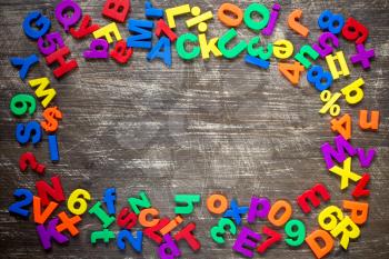  Top border of colorful  magnetic letters and numbers over a wooden background