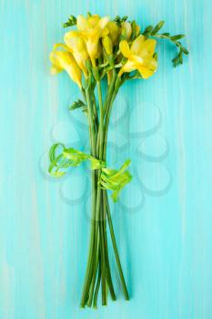Bouquet of freesia flowers lying on the wooden background