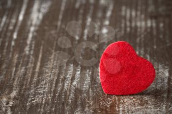   Old scratched wooden background with a small red heart