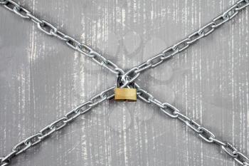 Steel chains and  padlock on the grey wooden background