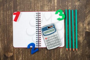   Digital calculator,open notebook,color numbers and pencil.Top view.