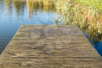 Old wooden pier on the lake at sunny day
