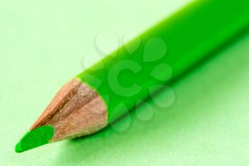 Close-up view of green pencil on paper background. Business or education concept.