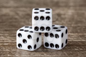 Three dice on dark wooden table background