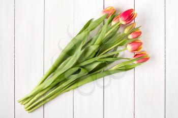 Tulips bouquet on white wooden background with copy-space