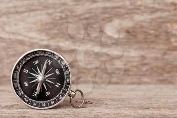 Magnetic compass on a wooden background. Concept of global travel , tourism and exploration.