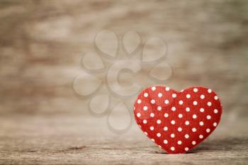 Red polka dot heart on wooden background
