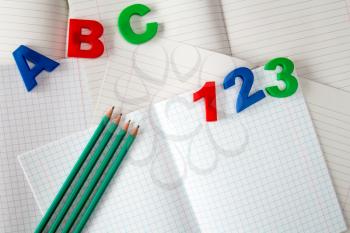 Colored numbers and letters on exercise books with four pencils