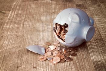 Broken piggy bank with and money on wooden background