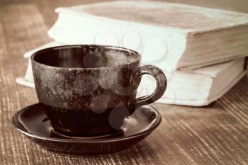 Coffee cup time concept. Coffee cup and books on wooden table.