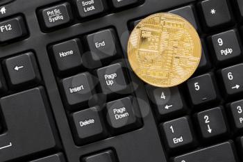 Golden BTC coin on computer keyboard.Top view.