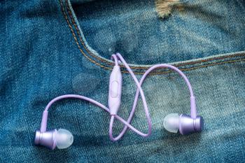 Earphones in the pocket of blue  jeans. The concept of music, sports, active lifestyle