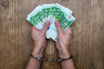 Hands in handcuffs with  money. Concept of arrest for bribery