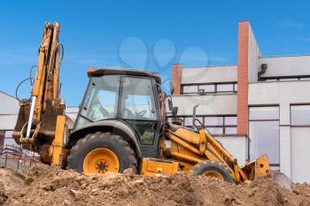 Yellow loader excavator works in construction site 