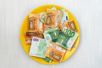 Plate with euro banknotes, view from above