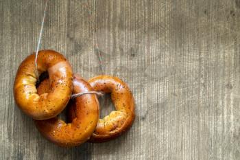 Bagels hang on rope on wooden background