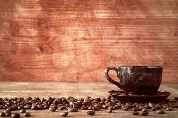 Coffee cup and coffee beans on old wooden background.