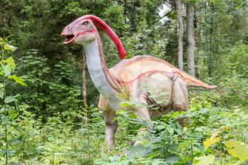 Big statue of Parasaurolophus dinosaur in a forest