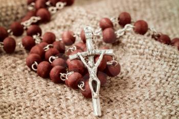 Close-up of christian rosary on old fabric background