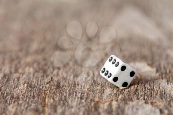 White cubic dice lying on a wooden background