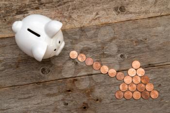 Piggy bank and coins arranged as a arrow. Financial concept. 