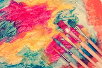 Dirty watercolor brushes and abstract colorful painting