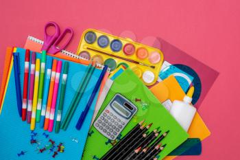 School supplies, stationery accessories on pink background. Flat lay, top view
