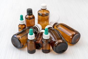 Pile of glass bottles with medicine or essential oil 