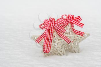 Christmas decorations stars with a red bows on the white fresh snow 