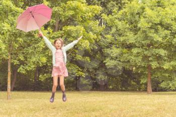  Happy girl with umbrella having fun in the park