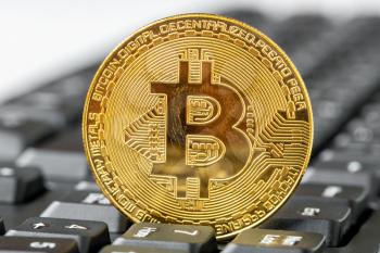 Golden Bitcoin as crypto currency on top of computer keyboard