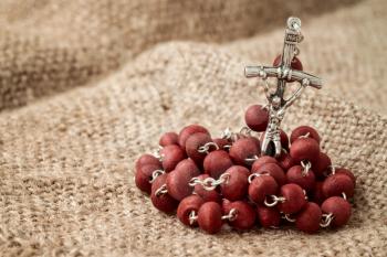 Close-up view of christian rosary on old fabric background