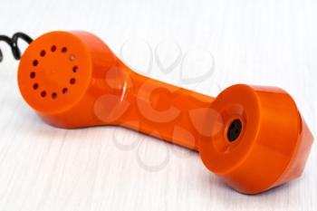Orange phone receiver close-up. Urgent business. Unsolved problem. Getting in touch.