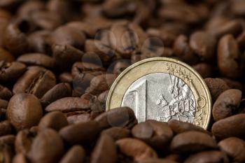 Europe coffee market. Roasted coffee beans and one Euro coin