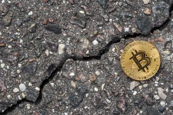 Shiny golden bitcoin on cracked asphalt. Fracture goes up as cryptocurrency market diagram