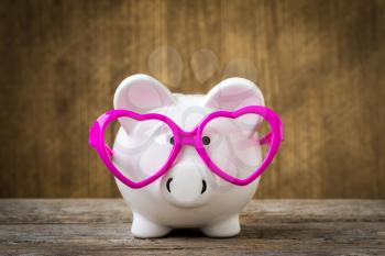 Piggy bank wearing a pink glasses 