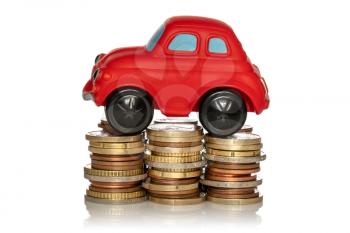 Saving for a new car. Red car and stack of coins isolated on white background