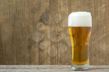 Glass beer on wood background with copyspace