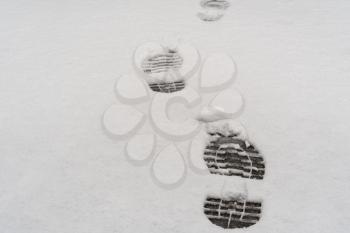 Footprints in fresh snow background, great concept for winter footwear