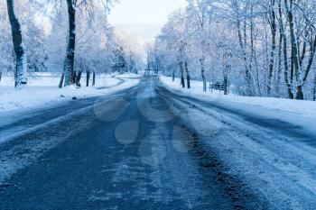 Winter dirty road without cars. Dangerous driving conditions in winter in cloudy weather.
