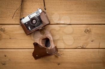Retro camera hanging on wood wall background, copy-space.