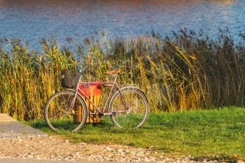 Old bicycle standing on the lake bank
