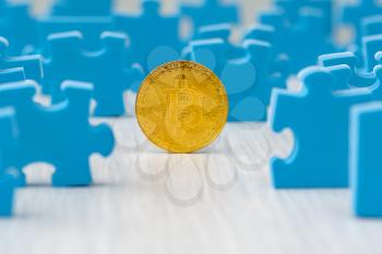 Golden Bitcoin surrounded by puzzle pieces, concept for understanding of investing to cryptocurrency
