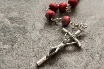 Catholic rosary on the stone background. Close-up view. Religion concept.