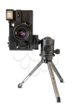 Old film camera on mini tripod, isolated on white background