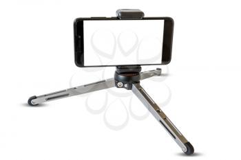 Tripod with smartphone with a blank screen. Isolated on white background. Copy-space.