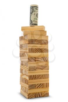 Dollar on the top of a tower made from wooden blocks. Business success concept.