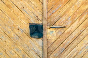 Old yellow wooden door of the barn or garage. Can be used as the background or texture for photo editors
